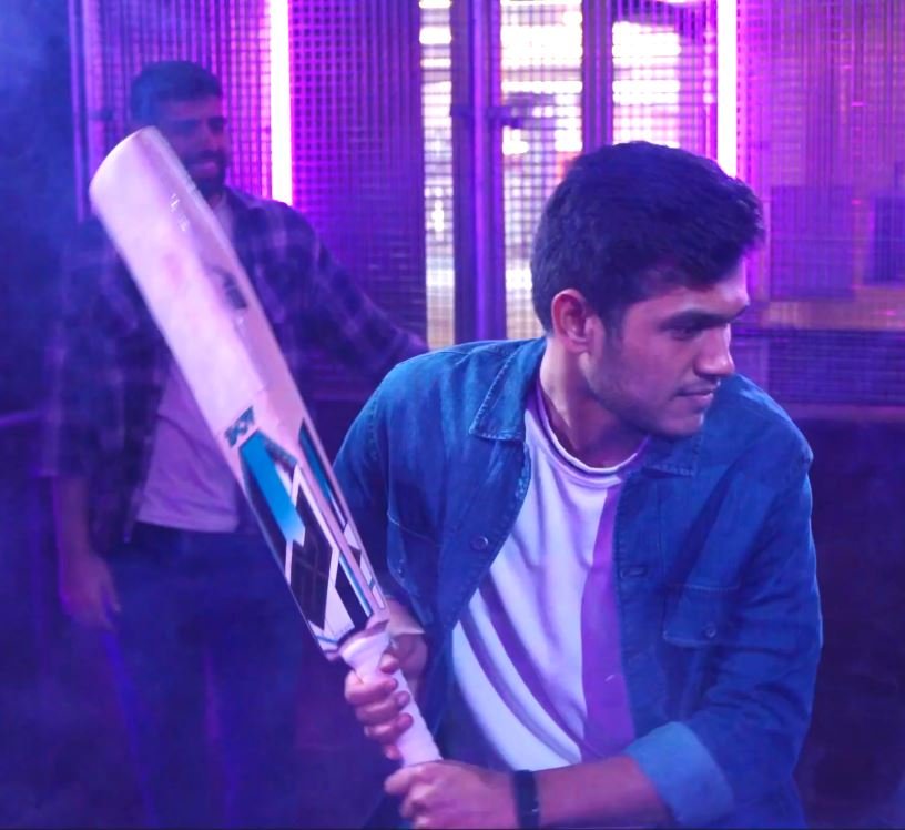 A batter takes guard in a neon-lit cricket net