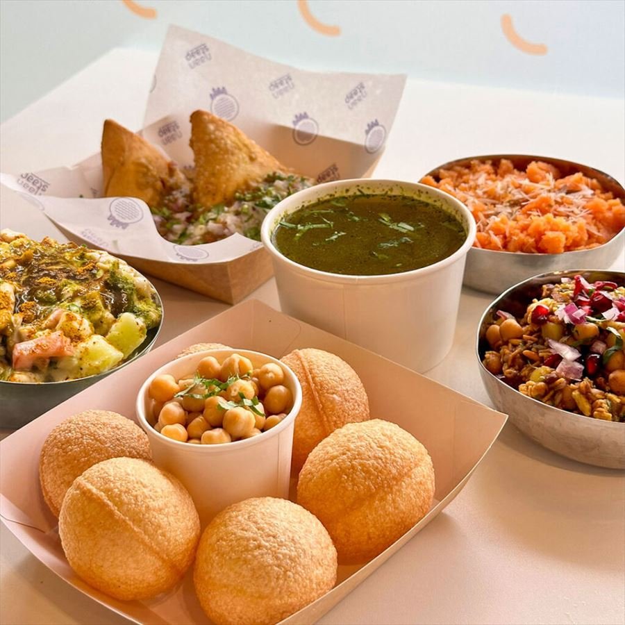 A spread of street-food dishes including samosas and pani puri